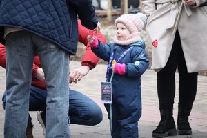 Na zdjęciu dziewczynka wręczająca czerwone serduszko