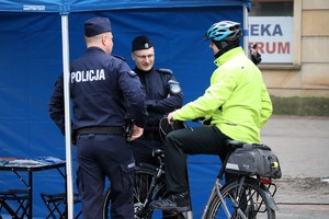 Na zdjęciu umundurowani policjanci rozmawiający z rowerzystą podczas Finału Wielkiej Orkiestry Świątecznej Pomocy