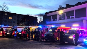 Na zdjęciu pojazdy uprzywilejowane z włączonymi sygnałami świetlnymi oraz policjanci, ratownicy medyczni oraz strażacy podczas hołdu dla tragicznie zmarłego ratownika medycznego