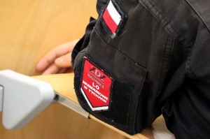 Na zdjęciu naszywka z nazwą szkoły oraz naszywka z flagą Rzeczypospolitej Polskiej na mundurze ucznia.