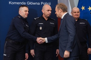 Premier Donald Tusk podaje rękę umundurowanemu policjantowi