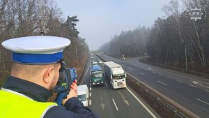 zdjęcie przedstawia policjanta dokonującego pomiaru odległości na drodze ekspresowej