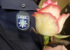 Na zdjęciu róża trzymana przez policjantkę
