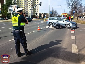 Na zdjęciu policjant ruchu drogowego oraz uszkodzone w wyniku zdarzenia drogowego pojazdy