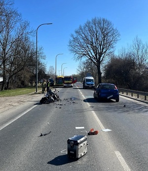 Na zdjęciu uszkodzony pojazd oraz motocykl na jezdni