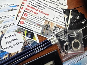 Na zdjęciu gadżety i materiały promocyjne dotyczące służby w Policji.
