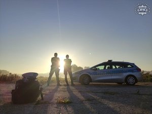 na zdjęciu policjanci z ruchu drogowego przy radiowozie