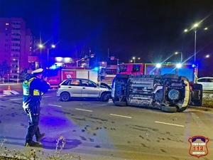 Na zdjęciu umundurowany policjant oraz pojazdy uszkodzone na skutek zdarzenia drogowego.