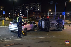 Na zdjęciu umundurowany policjant oraz pojazdy uszkodzone na skutek zdarzenia drogowego.