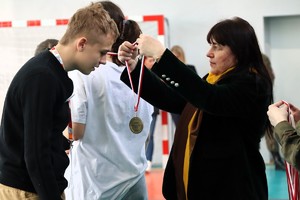 Na zdjęciu dyrektor szkoły wręczająca medal uczestnikowi olimpiady