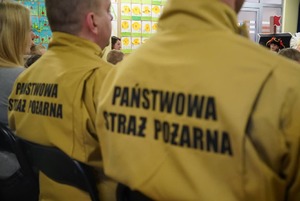 Na zdjęciu siedzący tyłem funkcjonariusze straży pożarnej