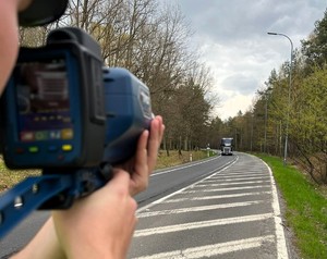 Na zdjęciu umundurowany policjant z urządzeniem do mierzenia prędkości