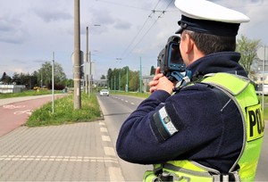 Na zdjęciu umundurowany policjant z urządzeniem do mierzenia prędkości