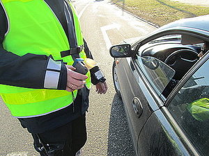 Umundurowany policjant sprawdzający trzeźwość kierowcy