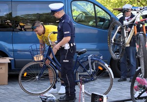Na zdjęciu umundurowany policjant ruchu drogowego oraz mężczyzna stojący przy rowerach