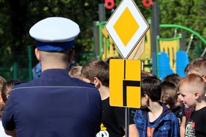 Na zdjęciu umundurowany policjant ruchu drogowego oraz uczniowie na miasteczku rowerowym