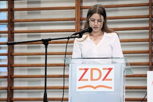 Na zdjęciu uczennica przemawiająca do mikrofonu