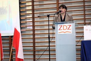 Na zdjęciu kobieta przemawiająca do mikrofonu