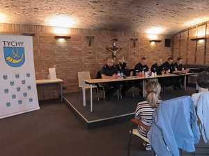 Na zdjęciu policjanci oraz funkcjonariusze straży miejskiej siedzący przy stole podczas debaty