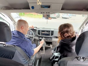 Na zdjęciu uczeń oraz policjant podczas prezentacji radiowozu