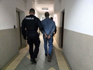 Policjanci prowadzący zatrzymanego mężczyznę