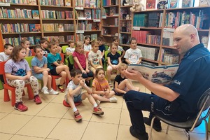 policjant czyta książkę dzieciom
