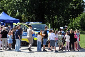 Na zdjęciu umundurowani policjanci oraz radiowóz podczas rodzinnego pikniku