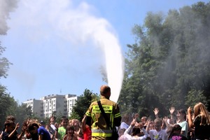 Na zdjęciu strażak lejący wodą z węża