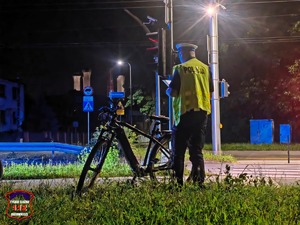 Na zdjęciu policjant stojący przy rowerze