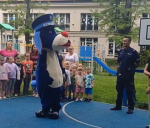 Na zdjęciu policjant oraz Sznupek na spotkaniu z dziećmi