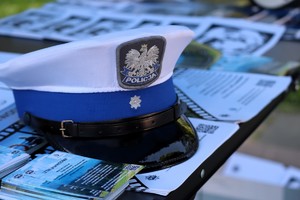 Na zdjęciu policyjna czapka na stoliku z ulotkami dotyczącymi bezpiecznego odpoczynku