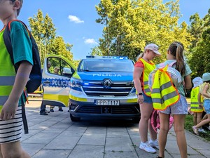 Na zdjęciu radiowóz Policji, obok dzieci