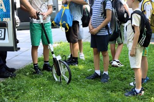 Na zdjęciu policjant z wózkiem mierniczym. Obok dzieci