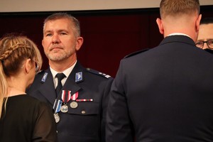 Na zdjęciu umundurowany policjant podczas wręczania odznaczeń