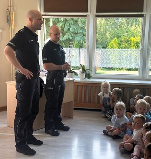 Na zdjęciu umundurowani policjanci oraz grupa dzieci w wieku przedszkolnym