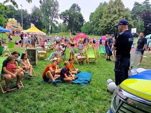 Na zdjęciu umundurowany policjant oraz grupa dzieci.