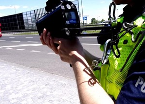 Policjant trzymający miernik prędkości