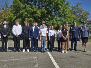 Goście honorowi stojący wraz z uczniami szkoły mundurowej