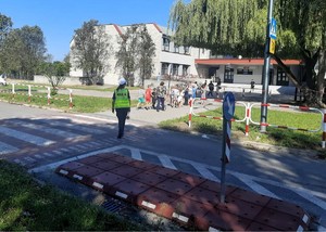 Na zdjęciu policjantka obok przejścia dla pieszych. Na przejściu dzieci