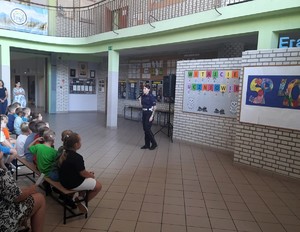 Na zdjęciu policjantka podczas prelekcji. Przed nią grupa dzieci.