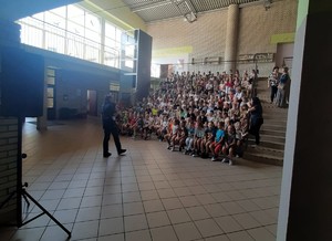 Na zdjęciu policjantka podczas prelekcji. Przed nią grupa dzieci.