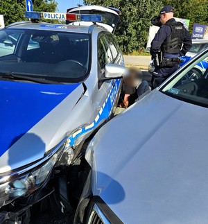 Na zdjęciu uszkodzony radiowóz oraz samochód osobowy