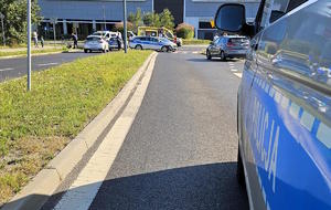 Na zdjęciu radiowozy, karetka pogotowia oraz samochód osobowy. Pojazdy stoją na jezdni