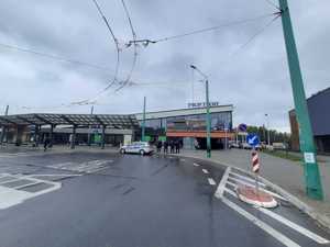 kolorowe zdjęcie przedstawiające policjantów oraz funkcjonariuszy Służby Ochrony kolei stojących obok oznakowanego radiowozu Policji na dworcu PKP w Tychach