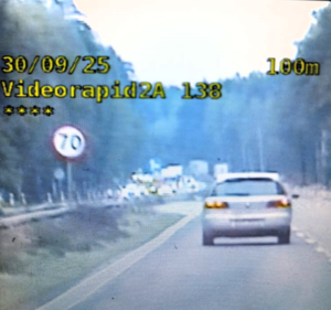 kolorowe zdjęcie ekranu video-rejestratora na którym widać fragment jezdni, pojazd, znak drogowy 70 km/h oraz parametry prędkości i odległości
