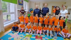 kolorowe zdjęcie przedszkolaków z umundurowanymi policjantami