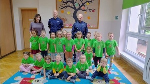 kolorowe zdjęcie przedszkolaków z umundurowanymi policjantami