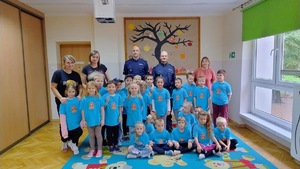 kolorowe zdjęcie przedszkolaków z umundurowanymi policjantami