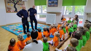kolorowe zdjęcie przedszkolaków z umundurowanymi policjantami