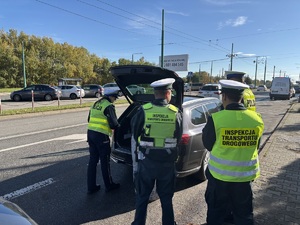 Kolorowe zdjęcie umundurowanych funkcjonariuszy policji oraz ITD przeprowadzających kontrolę pojazdu TAXI.